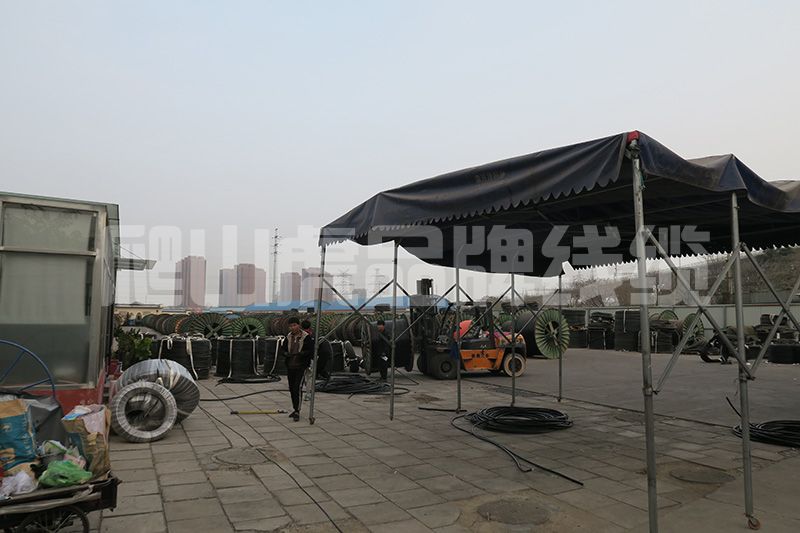 橡套電纜的橡皮發(fā)粘和銅絲發(fā)黑的原因從下面兩個方面來分析   橡套電纜是由多股的細銅絲為導體，外包橡膠絕緣和橡膠護套的一種柔軟可移動的電纜品種。 一般來講，包括通用橡套軟電纜，電焊機電纜，潛水電機電纜，無線電裝置電纜和攝影光源電纜等品種。銅絲發(fā)黑的原因是多種因素造成的，不僅僅是橡皮的配方問題，還與銅絲本身所處的狀態(tài)、橡膠加工工藝、橡膠硫化工藝、電纜的結構、護套橡膠配方、生產環(huán)境等諸多因素有關。下面爬山虎電力線纜小編為您介紹下：    橡皮發(fā)粘和銅絲發(fā)黑的原因分析  銅絲本身的原因在廿世紀五十到六十年代，國內大多數(shù)廠家均使用普通銅桿，銅含量為99.99%，均為有氧銅桿，生產方法都是銅錠加熱后經多道壓延后制得黑色銅桿，經過大、中、小拉將銅桿制成比較細的銅絲。因為銅本身不是無氧銅，在加工過程中銅絲表面難免出現(xiàn)氧化。到了廿世紀八十年代，國內引進了無氧銅桿的先進生產技術，以及國內自行開發(fā)的無氧銅桿生產技術，使整個電線電纜行業(yè)均用上了無氧銅桿，這無疑是改善了銅絲的發(fā)黑問題。但由于對銅桿的加工，特別是韌煉工藝的掌握以及加工好的銅線芯存放的條件不好，使銅線芯本身已有輕微的氧化，這也是銅絲發(fā)黑的原因之一。    橡膠配方的原因廿世紀五十年代，橡膠絕緣均采用天然膠和丁苯膠并用配方。由于絕緣橡皮直接與銅線接觸，所以就不能直接使用硫磺作硫化劑，即使用很少的硫磺也會使銅線發(fā)黑。必須使用一些能夠分解出游離硫的化合物，如前面提到過的促進劑TMTD、硫化劑VA-7，同時還要配合一些硫化促進劑來提高硫化速度和硫化程度，確保絕緣橡皮的物理機械性能和電氣性能。    但從絕緣橡皮的彈性、強力和永久變形看，都不如加有硫磺的橡皮（如果不考慮銅絲發(fā)黑的話）。幾十年的實踐已經證實TMTD無法解決銅絲的發(fā)黑問題。另外，絕緣橡皮要有各種顏色，紅、藍、黃、綠、黑是基本顏色，這些顏色的出現(xiàn)也會促使橡皮發(fā)粘和銅絲發(fā)黑。配方中的主要填充劑是輕質碳酸鈣和滑石粉，由于價格的關系，有些廠家為了降低成本，用價格特別便宜的碳酸鈣和滑石粉，這些填充劑粒子粗、游離堿的含量大、雜質多，所以物理機械性能比較差，電性能不好，還容易造成銅絲發(fā)黑。還有的廠用活性超細碳酸鈣來提高絕緣橡皮的物理機械性能，而活性鈣多數(shù)是用硬脂酸來處理的，這種酸也是促使銅絲發(fā)黑的原因。    硫化劑VA-7的使用，可以改善銅絲發(fā)黑，但由于硫化程度不夠，橡皮的永久變形大，會造成橡皮發(fā)粘。特別是加入促進劑ZDC以后，提高了硫化速度，為了防止焦燒，還要加入促進劑DM來延緩焦燒時間。    從促進劑ZDC的結構看，是在TETD結構中兩個相連接的硫中間接上一個金屬鋅，結構式為： S S H5C2 ‖ ‖ H5C2 ＞N-C-S-Zn-S-C-N＜ H5C2 H5C2 與TETD結構式 S S H5C2 ‖ ‖ H5C2 ＞N-C-S-S-C-N＜ H5C2 H5C2 十分接近，在配方中還無法避開和秋蘭姆相似的結構銅絲發(fā)黑可能時間略長一點，但沒有從根本上解決。    正在上傳...    從電線電纜結構分析  銅的催化老化是橡皮發(fā)粘的重要原因前蘇聯(lián)電纜科學研究院試驗證明：硫化過程中銅從與橡膠接觸處滲入到絕緣橡膠中，1.0-2.0mm厚度的絕緣橡皮含銅0.009-0.0027%。眾所周知，微量銅對橡皮有極大的破壞作用，也就是我們通常說的重金屬對橡膠的催化老化。    在絕緣硫化過程中，秋蘭姆析出若干游離硫與銅反應，形成活性含銅基團： CH3 │ CH2-CH-C-CH2- │ │ S S │ │ Cu Cu 在老化時，較弱的-S-S-鍵斷裂，形成活性含銅基：Cu-S-，它與橡膠作用，同時與氧作用，破壞橡膠的長鍵分子，使橡膠變軟變粘，是低分子鏈的組合。    法國橡膠研究院研究發(fā)粘重現(xiàn)問題時也指出：如果橡膠中含有有害的金屬，如：銅、錳等重金屬鹽類，那么不管促進劑的種類，均會發(fā)生橡膠發(fā)粘現(xiàn)象。    橡套電纜中硫磺向絕緣橡皮和銅線表面的遷移前蘇聯(lián)科學家應用放射性同位素證實了電纜護套橡膠中硫擴散的可能性。以天然橡膠為基的硫化膠中，在130-150℃的溫度下，游離硫的擴散系數(shù)約為10-6cm2/s。    連續(xù)硫化的生產廠，硫化護套橡膠時，溫度在185-200℃之間，這個擴散的系數(shù)就更大。由于橡套游離硫的擴散，改變了秋蘭姆橡膠的結構，可能形成多硫鍵。這些多硫化合物通過化學分解和化合實現(xiàn)遷移，即